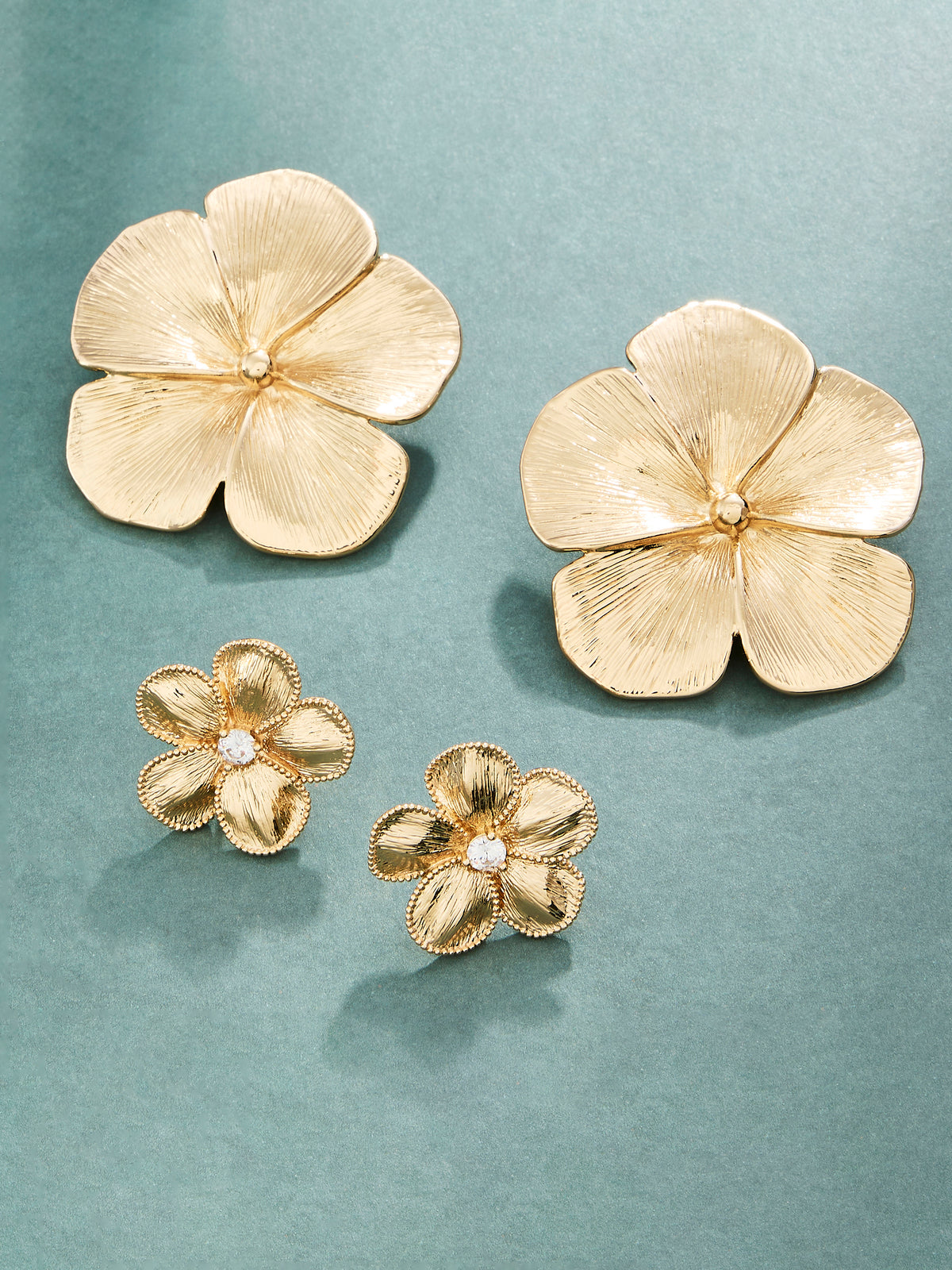 Flower earrings on a teal/blue background