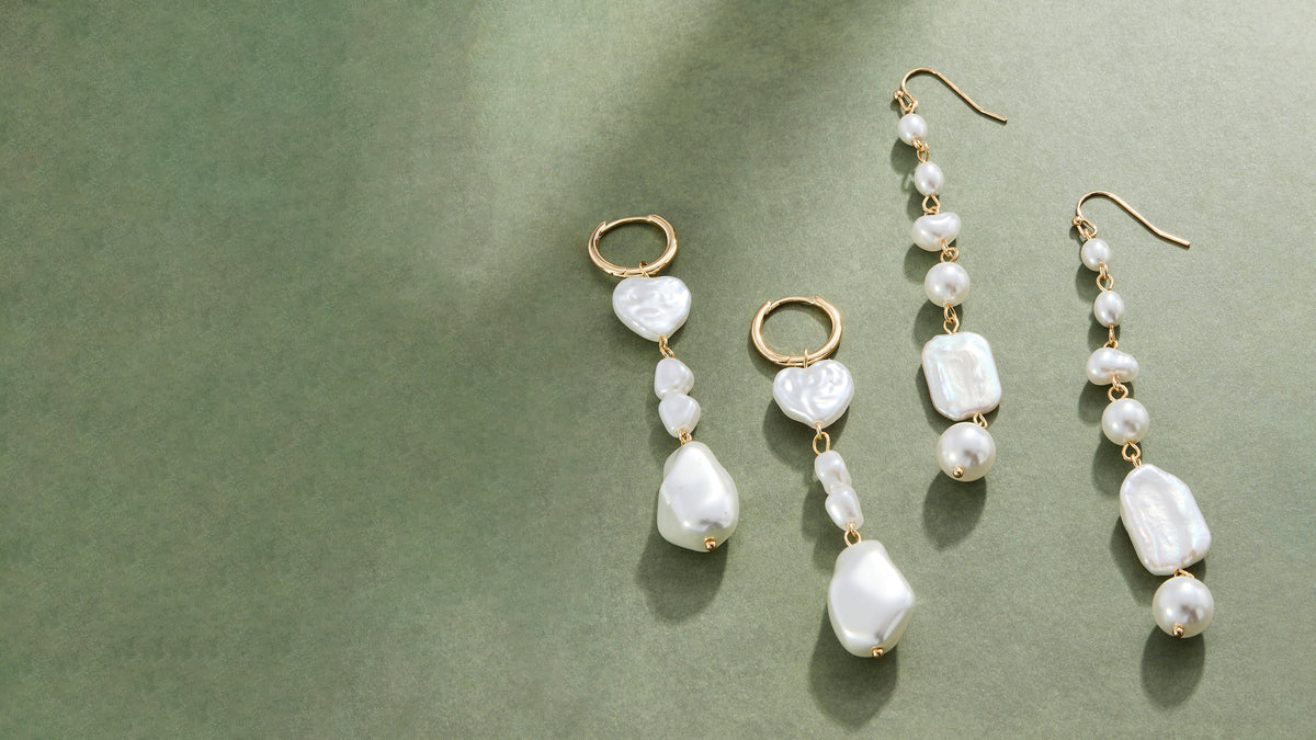 two pairs of pearl earrings on a green background